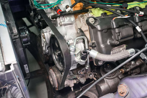 Earl's Remote Reservoir Adapter Kit for Saginaw Type II Power Steering Pumps Includes -10 AN Reservoir Fitting, Flow Valve, and Retaining Bracket Front View Silver