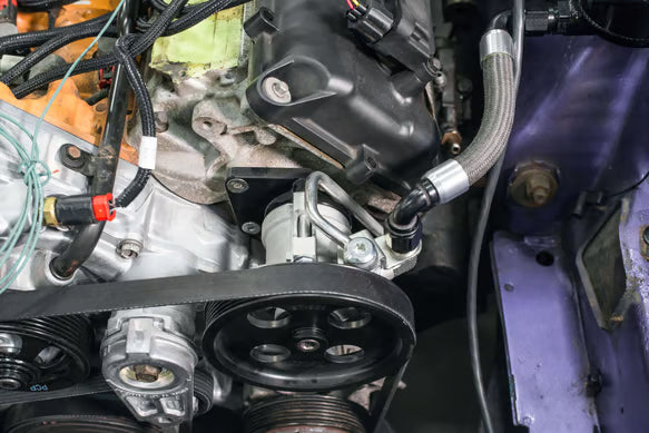 Earl's Remote Reservoir Adapter Kit for Saginaw Type II Power Steering Pumps Includes -10 AN Reservoir Fitting, Flow Valve, and Retaining Bracket Front View Silver